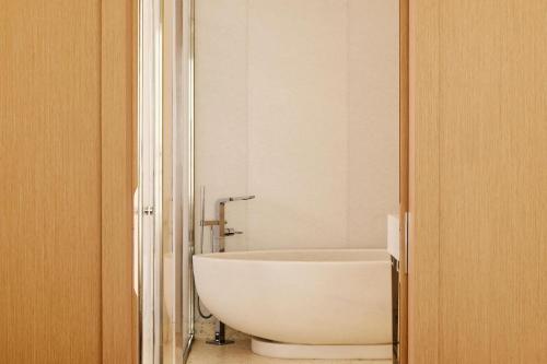 a bathroom with a white tub and a toilet at The Maybourne Riviera, Maybourne in Roquebrune-Cap-Martin