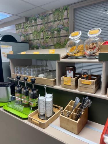 a store counter with food items on a shelf at Premiere Classe Amiens Est - Glisy in Glisy