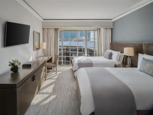 a hotel room with two beds and a television at Kempinski Hotel Cancun in Cancún
