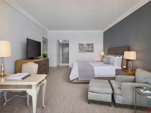 a hotel room with a large bed and a desk at Kempinski Hotel Cancun in Cancún