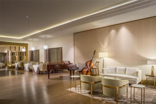a living room with a piano and a couch and chairs at Kempinski Hotel Cancun in Cancún