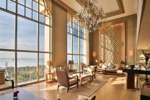 a living room with a chandelier and large windows at Kempinski Hotel Cancun in Cancún