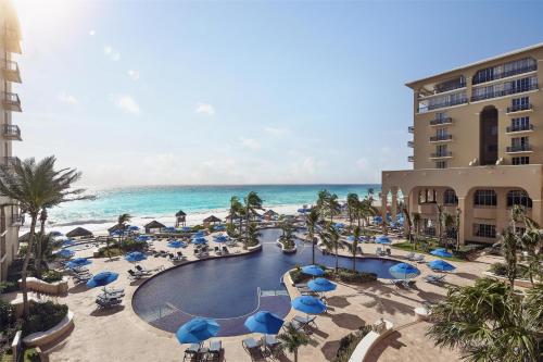 a view of a resort with a pool and the ocean at Kempinski Hotel Cancun in Cancún