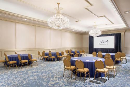 a conference room with tables and chairs and a screen at Kempinski Hotel Cancun in Cancún
