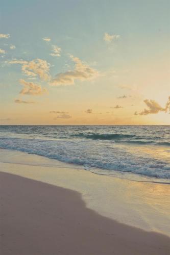 a person standing on a beach with the ocean at Kempinski Hotel Cancun in Cancún