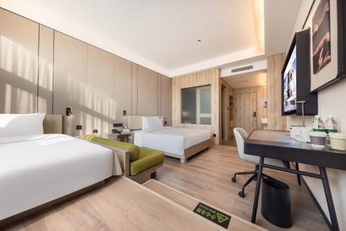 a hotel room with two beds and a desk at Atour Hotel Xian Greater Wild Goose Pagoda in Xi'an