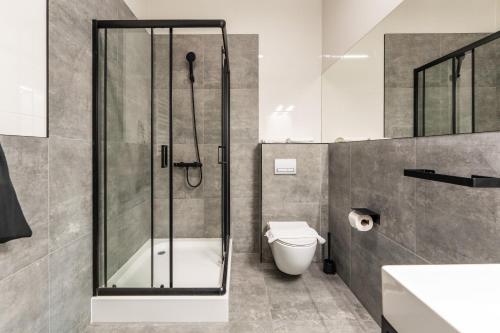 a bathroom with a shower and a toilet and a sink at IND.U Apartamenty in Kołobrzeg