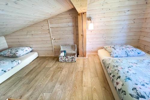a bedroom with two beds in a wooden cabin at Chatka in Roztiezi in Roztěž