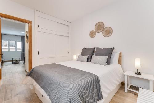 a white bedroom with a large bed and a window at Home2Book Chic Apartment Near The Sea, La Garita in La Garita