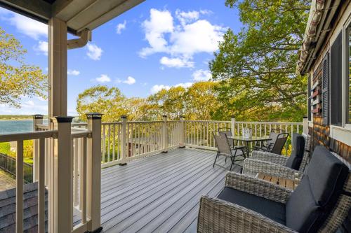 a deck with chairs and tables on a house at Coastal Comfort with Stunning Harbor Views home in Plymouth