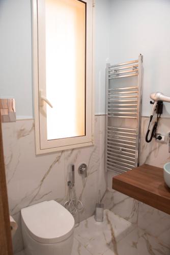 a bathroom with a toilet and a sink and a mirror at La Dolce Vita rooms & suite in Agrigento