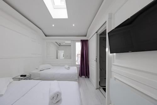 une chambre blanche avec un lit et une télévision à écran plat dans l'établissement Cannes 3 bedrooms apartment - 14HV, à Cannes