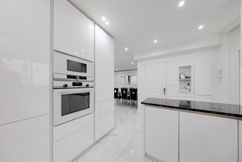 une cuisine blanche avec des armoires et des appareils blancs dans l'établissement Cannes 3 bedrooms apartment - 14HV, à Cannes