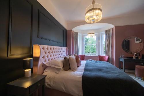 a bedroom with a large bed with a large window at Blakeney House in Blakeney