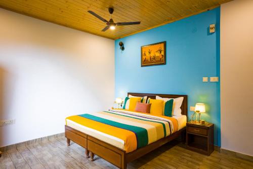 a bedroom with a bed with a blue wall at Alaya Stays Archee's 6 BHK Nature Retreat with Game Lounge & Open Dining in Kasauli
