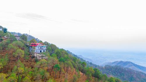 a building on the side of a mountain at Alaya Stays Archee's 6 BHK Nature Retreat with Game Lounge & Open Dining in Kasauli