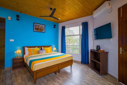 a blue bedroom with a bed and a window at Alaya Stays Archee's 6 BHK Nature Retreat with Game Lounge & Open Dining in Kasauli