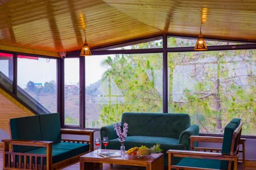 a living room with two chairs and a table at Alaya Stays Archee's 6 BHK Nature Retreat with Game Lounge & Open Dining in Kasauli