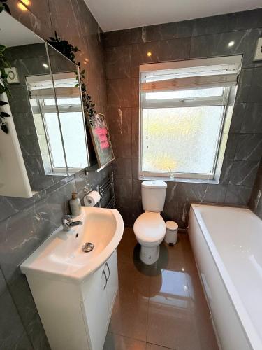 a bathroom with a sink and a toilet and a tub at 1 bed modern apartment walking distance from shopping mall in Golders Green