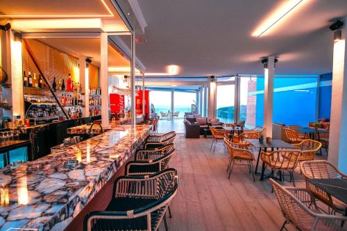 a restaurant with a bar with chairs and tables at Valtos View in Parga