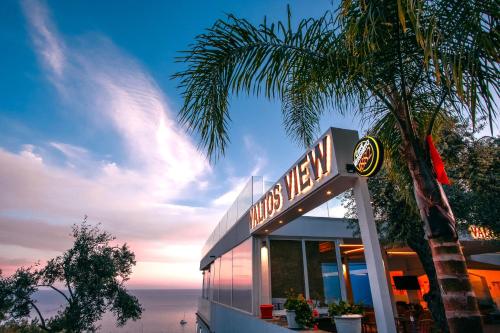 a neon sign for a restaurant next to a palm tree at Valtos View in Parga