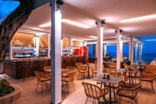 a restaurant with tables and chairs and a bar at Valtos View in Parga