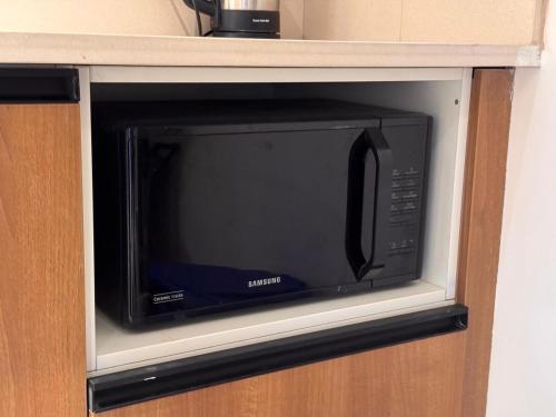 a microwave oven sitting inside of a kitchen at Stay Central Loft Panampilly in Cochin
