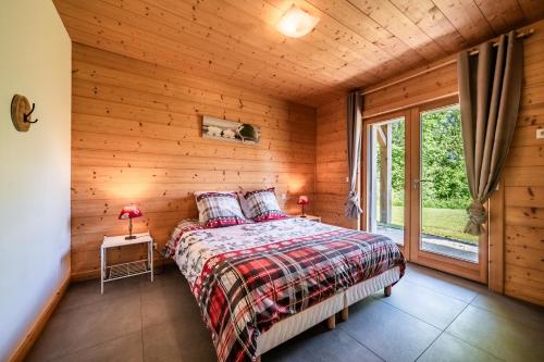 une chambre avec un lit dans une cabane en bois dans l'établissement Les Gites Leyetaz, à Châtillon-sur-Cluses