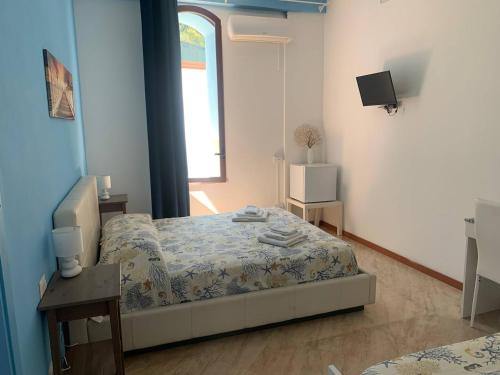 a small bedroom with a bed and a window at BorgoMarino's Room in Cefalù