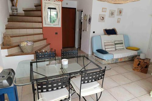 Cette chambre comprend une table et des chaises en verre ainsi qu'un lit. dans l'établissement House 3 rooms with garden near the sea, à Bandol