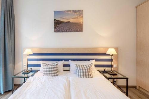 a bedroom with a bed with two side tables at Leuchtturm an der Seebrücke in Zingst
