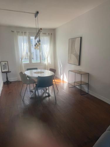 un salon avec une table et des chaises de salle à manger dans l'établissement Appartement au cœur de Rouen, à Rouen