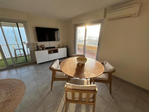 un salon avec une table, des chaises et une télévision dans l'établissement Panoramic view, Quiet, Modern, Wi-Fi, Parking, à Canet