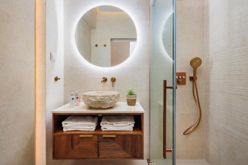 a bathroom with a sink and a shower with a mirror at Beach villa with ocean view and rooftop cinema in Guia