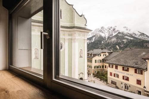 an open window with a view of a building at The Post Mountain Residence in Dobbiaco