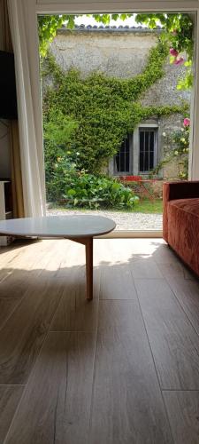 - une table basse dans une chambre avec fenêtre dans l'établissement Maison Irondas, à Saint-Pierre-dʼAurillac