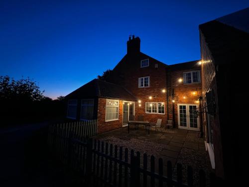 a house lit up at night with lights at Wellbet Farm in Swinderby