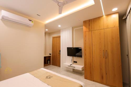 a bedroom with a large wooden cabinet and a tv at The Meera Hotel in Ujjain