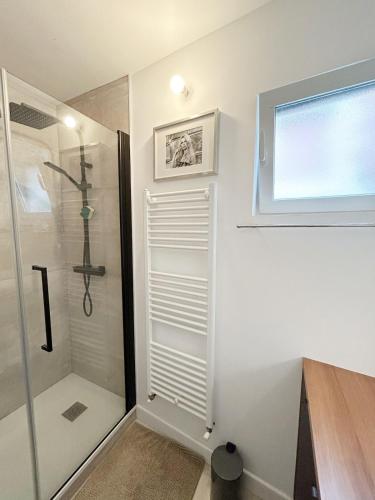 une salle de bain avec une douche avec une porte vitrée dans l'établissement Grand T2 direct sur la plage Arcachon Pereire, à Arcachon