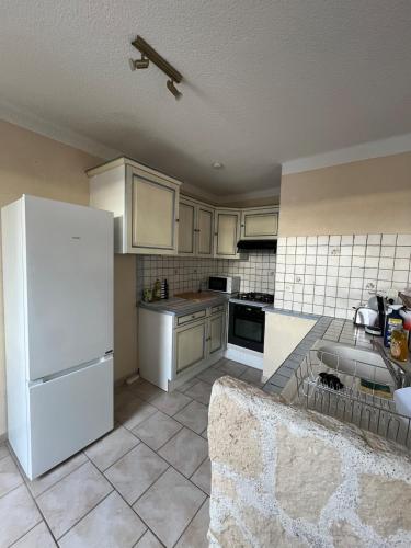 Il comprend une cuisine équipée d'appareils électroménagers blancs et d'un réfrigérateur blanc. dans l'établissement Appartement 3 chambres proche du centre, à Avignon