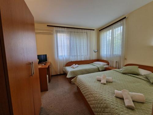 a hotel room with two beds with towels on them at Rebeka Guest House in Tryavna