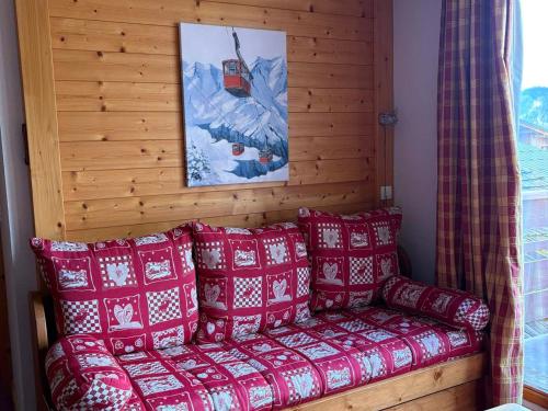 圣母贝莱克Appartement T2 proche des pistes avec balcon et accès Wi-Fi - FR-1-807-71的客房内的沙发配有红色和白色枕头