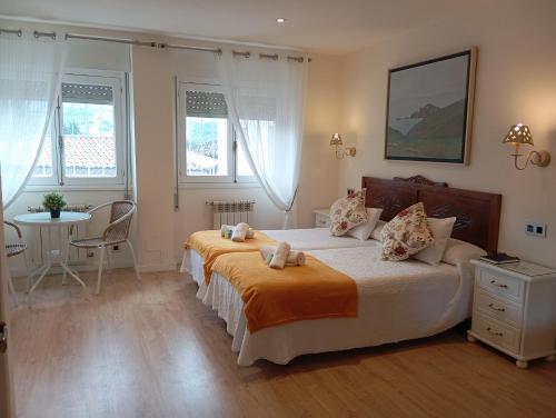 a bedroom with a bed with two stuffed animals on it at Hotel Alvaro frente Palacio-Museo Selgas in Cudillero