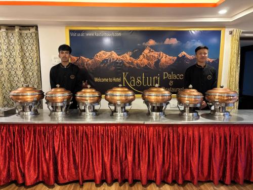 a group of three men standing behind a table with trophies at Hotel KASTURI PALACE & RESTAURANT DARJEELING in Darjeeling
