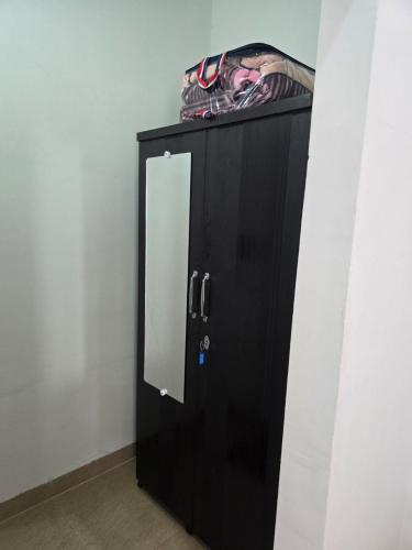 a black cabinet with a mirror on top of it at Kaushal Height in Mānpur