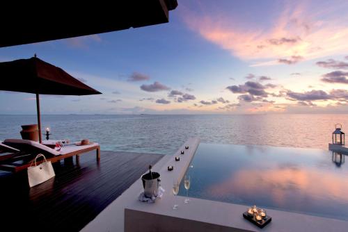 a swimming pool on the deck of a resort with the ocean at Lily Beach Resort and Spa - All Inclusive in Dhangethi