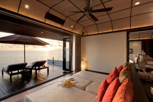 a bedroom with a large bed with a view of the ocean at Lily Beach Resort and Spa - All Inclusive in Dhangethi