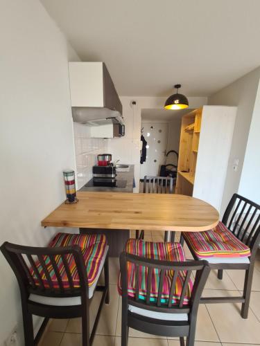 une cuisine avec une table en bois et deux chaises dans l'établissement Joli studio calme et balcon au cœur du Lubéron proche du centre et gare, à Cavaillon
