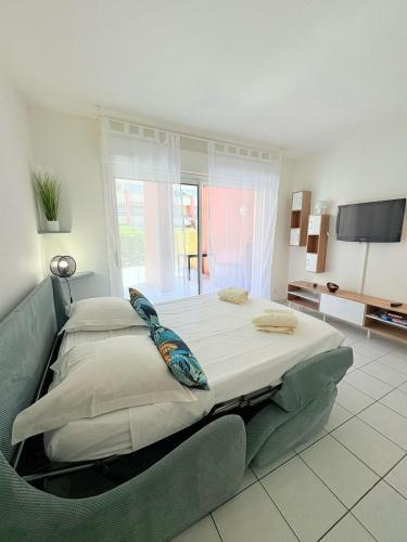 - une grande chambre avec un grand lit et une télévision dans l'établissement Le Toucan, Front de mer -1 min des plages, à Sète