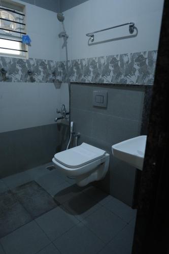 a bathroom with a toilet and a sink at Kalgadde in Chikmagalūr